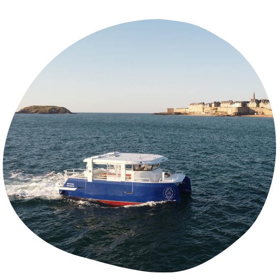 Blue boat on water near historic coastal town with clear sky.