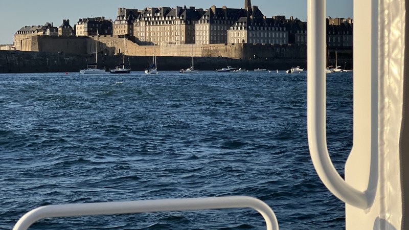 View of a coastal city with historic buildings from a boat.