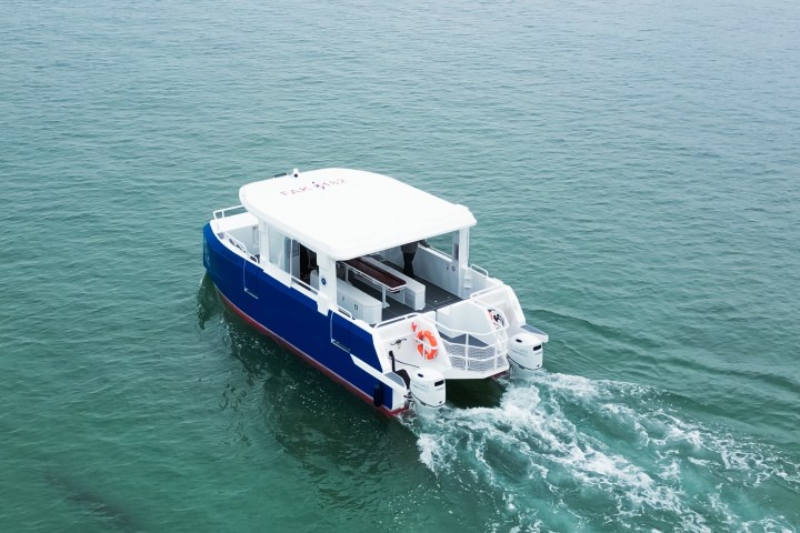 Small blue and white boat moving on calm green water.