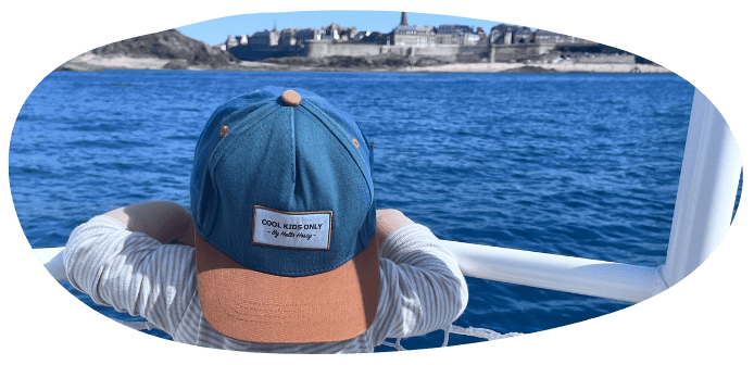 Person with cap looking at ocean from a boat